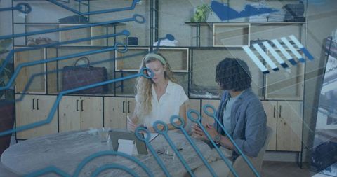 Creative team collaborating over tablet with digital circuit overlay for tech brainstorming