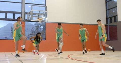 Diverse Male Athletes Performing Basketball Warm-Up Drills in Gymnasium