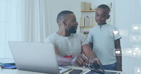 Father and son exploring digital world at home office