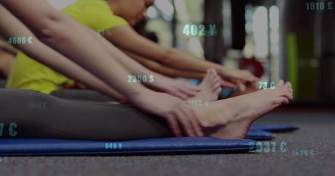 Women practicing yoga group fitness class dynamic movement