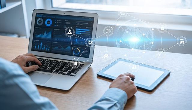 Business analyst analyzing digital dashboards on laptop and tablet with holographic overlay