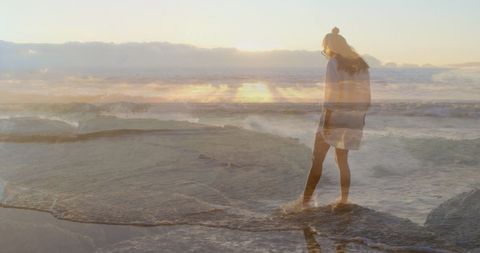 Woman Enjoying Ocean Waves During Serene Sunset