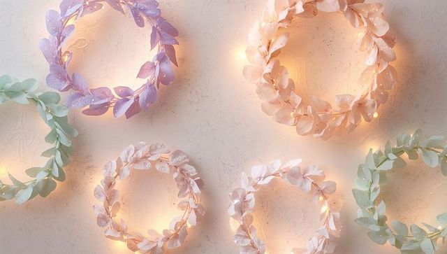 Pastel leaf wreaths with warm fairy lights flatlay for seasonal decor and wedding styling