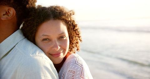 Happy Multiracial Couple Smiling at Beach During Romantic Sunset