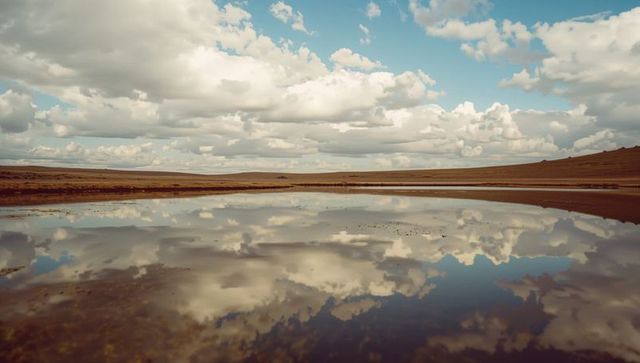 Reflective Shallow Lake Surface Under Cloudy Open Sky
