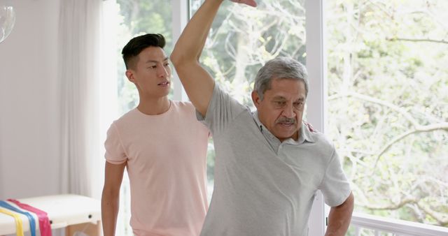 Physical Therapist Assisting Elderly Man with Arm Exercise at Home - Download Free Stock Images Pikwizard.com