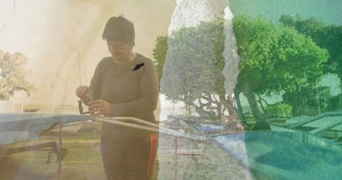 Senior individual adjusting fishing reel by lakeside with relaxing atmosphere