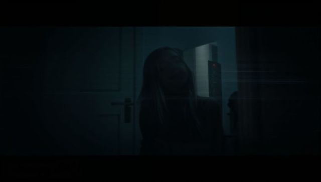 Teenage Girl Sitting Reflectively in Minimalist Urban Hallway