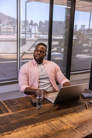 Focused businessman at modern office desk downtown skyline view