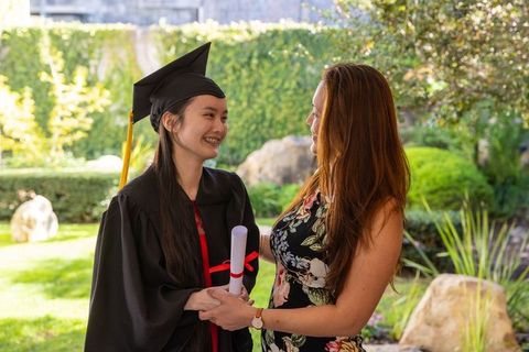 Proud Mother Congratulates Graduating Daughter in Scenic Garden