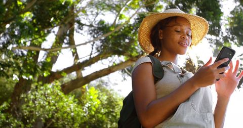 Young Woman Texting Phone Outdoors on Sunny Day