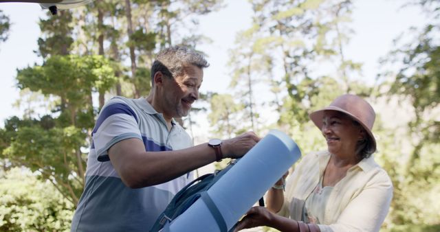 Active Senior Couple Packing Yoga Mat for Outdoor Adventure - Download Free Stock Images Pikwizard.com