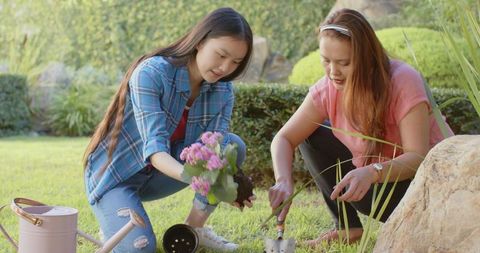 Mother and Daughter Bonding Through Gardening in Sunny Backyard