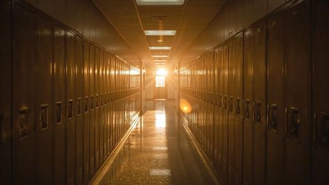 Empty school corridor with lockers and sunset glow lighting