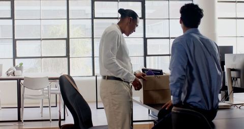 Coworkers Packing Office Items, Emphasizing Teamwork and Transition