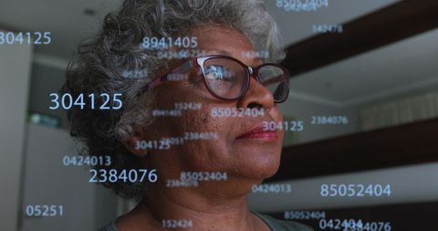 Elderly African American Woman Analyzing Data with Digital Interface