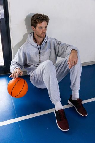 Athletic Man Relaxing on Basketball Court in Urban Activewear