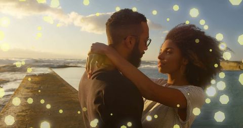 Romantic Couple Embracing by Ocean with Glowing Lights Effect