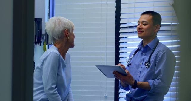 Senior Woman Consulting with Friendly Asian Male Doctor - Download Free Stock Images Pikwizard.com