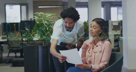 Office professionals collaborating on document in modern workspace