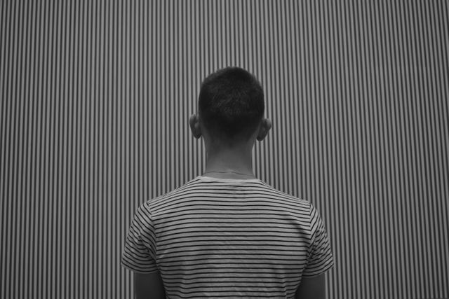 Person Facing Wall with Vertical Stripes Black and White - Download Free Stock Photos Pikwizard.com