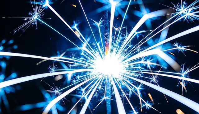 Blue sparkler starburst emitting radiant streaks and glowing embers for festive moments