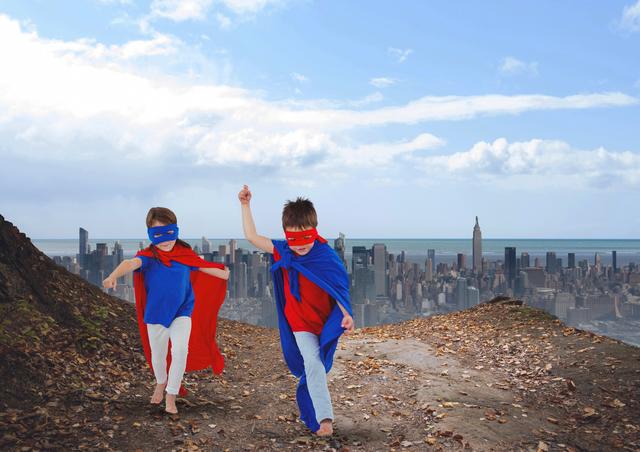 Children playing on a hill in superhero costumes with red and blue capes, overlooking a vast cityscape. Ideal for themes of childhood imagination, adventure, creativity, and outdoor fun. Perfect for use in educational materials, imaginative play promotions, children's storybook illustrations, and advertisements for kids' products related to play and creativity.