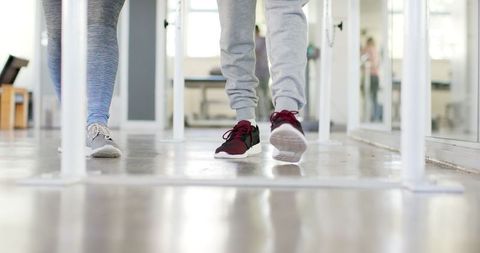 Rehabilitation exercise with therapist on parallel bars