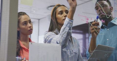 Team Collaborating on Glass Board for Innovative Ideas