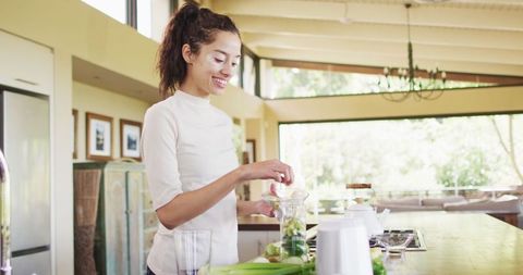 Woman Preparing Fruit Smoothie in Bright Modern Kitchen