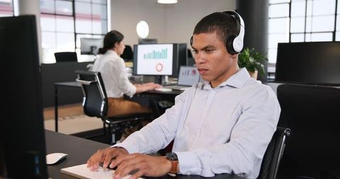 Focused man working in modern office with headphones