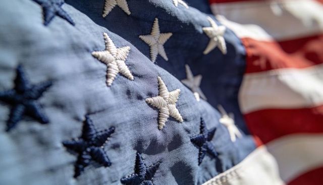 Displaying embroidered american flag stars in sunlit macro fabric close-up