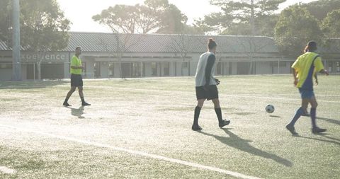 Soccer Players Practicing on Sunlit Outdoor Field
