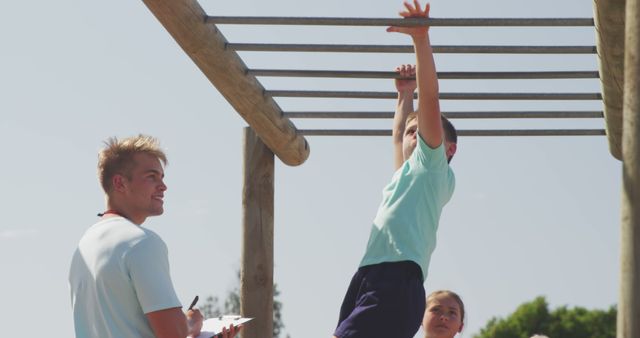 Child Playing on Monkey Bars with Coach Encouraging Outdoors - Download Free Stock Images Pikwizard.com