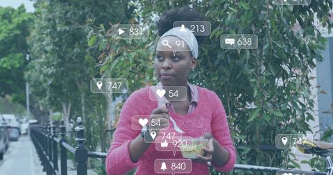 Woman Engaging with Social Media Over Lunch in Urban Environment