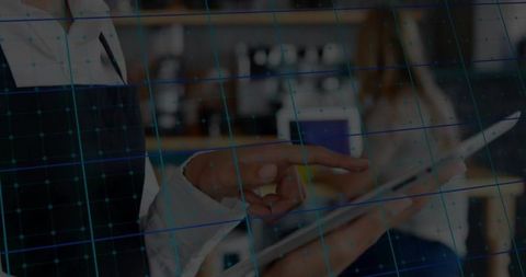 Colleagues Pointing at Tablet While Collaborating with Blue Digital Grid Overlay