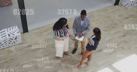 Diverse Professionals Engaged in Data Discussion in Office