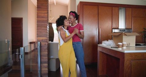 Joyful Women Dancing in New Home Amidst Unpacking