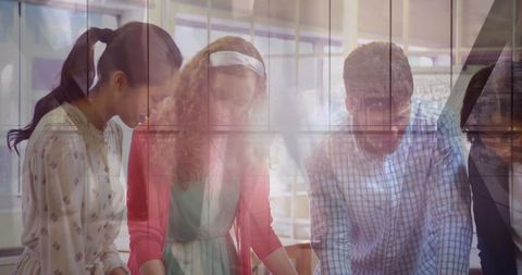 Focused Team Collaborating Over Blueprints in Modern Office