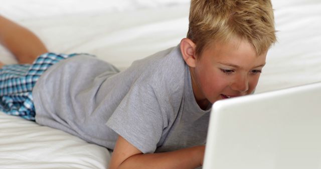 Boy lying on bed using laptop - Download Free Stock Images Pikwizard.com