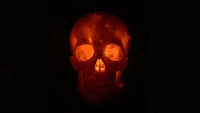 Eerie glowing skull with orange led light in dark setting