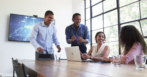 Diverse colleagues celebrating successful project in office