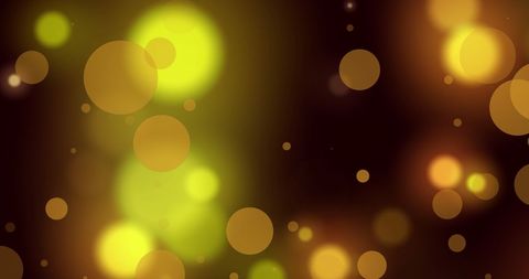 Abstract glowing yellow and orange light spots on dark background