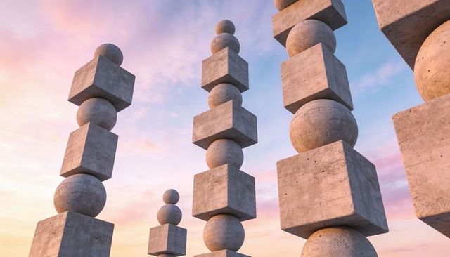 Balancing concrete cubes and spheres rising into pastel sunset sky vertical sculpture