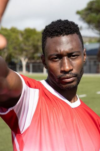 Focused african american athlete posing on outdoor sports field