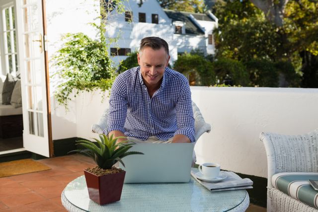 Mature businessman using laptop in outdoor cafe