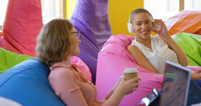 Young Women Enjoy Relaxing Coffee and Music on Colorful Bean Bags - Download Free Stock Images Pikwizard.com