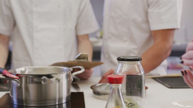 This vibrant video showcases a female chef standing by a table and preparing food while other chefs work in the background. Ideal for representing teamwork in culinary schools or professional chef training programs. It can be used for cooking blogs, culinary school promotions, restaurant advertisements, and educational materials focusing on culinary arts.