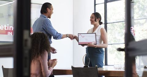 Celebratory office meeting with award presentation