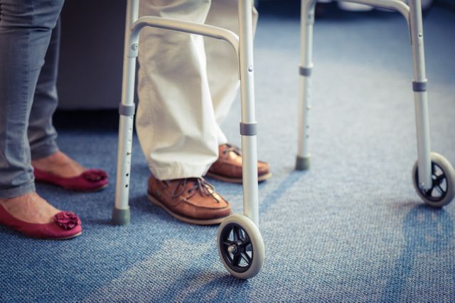 Senior woman assisting senior man with a walker. Ideal for use in healthcare, elderly care, rehabilitation, and caregiving contexts. Can be used in articles, blogs, and advertisements related to senior care, mobility aids, and physical therapy.